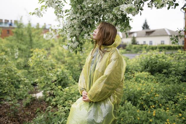 Young woman wearing raincoat at back yard of house model released, Symbolfoto, VCF00549