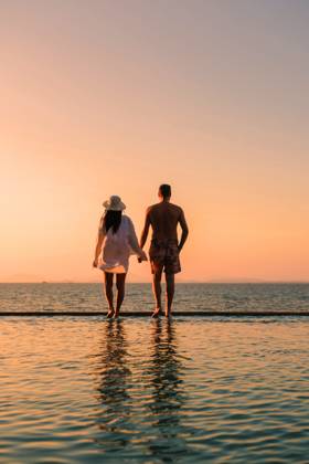 Romantischer Spaziergang bei Sonnenuntergang auf der Insel Koh Munnork in Rayong, Thailand A couple of men and women walk hand in hand along the edge of a tranquil infinity pool at Koh Munnork Island, soaking in the breathtaking sunset over the serene waters of Thailand. ,model released, Symbolfoto Copyright: xZoonar.com FokkexBaarssenx 22679617 ,model released, Symbolfoto ,property released