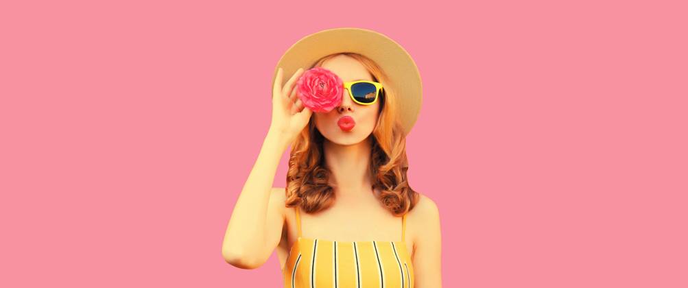 Sommer Porträt der stilvollen jungen Frau Modell bläst Kuss mit Blütenknospen auf rosa Hintergrund Summer portrait of stylish young woman model blowing kiss with flower buds looking for something in round straw hat on pink studio background ,model released, Symbolfoto Copyright: xZoonar.com VeronikaxKornevax 22702381 ,model released, Symbolfoto ,property released