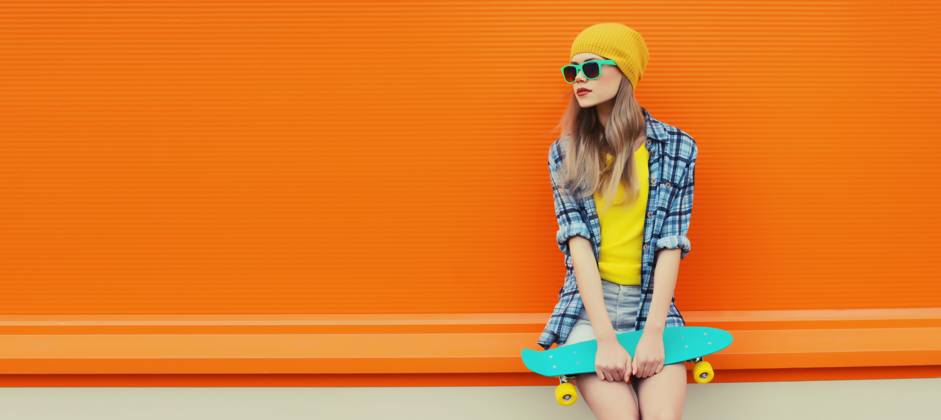 Sommer Porträt der stilvollen jungen Frau mit Skateboard in bunte Kleidung auf orange Hintergrund Summer portrait of stylish young woman with skateboard in colorful clothes, yellow hat looking away posing on orange background, blank copy space ,model released, Symbolfoto Copyright: xZoonar.com VeronikaxKornevax 22713482 ,model released, Symbolfoto ,property released