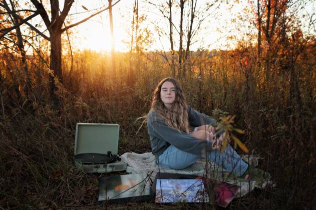 IMAGO Creative, Jahreszeit Sommer, Sommerferien Gorgeous teen girl listening to record player in sunny field Wooster, Ohio, United States CR_JOKU250217-1644783-01 ,model released, Symbolfoto