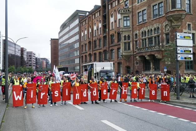 Hamburg Demonstration the Dockworkers with Verd I Flags Banner transparent with the Inscription We are the Port Hundreds demand more Wages and better Working conditions the Demonstration led to mas