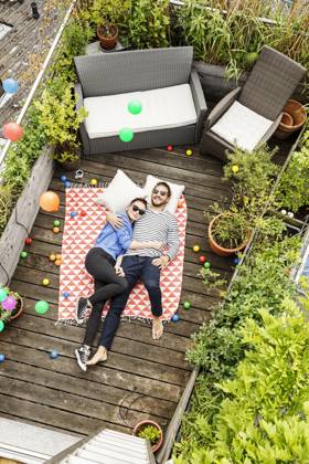 Young couple relaxing on their balcony, lying on blanket with arms around model released, Symbolfoto property released, PESF01172
