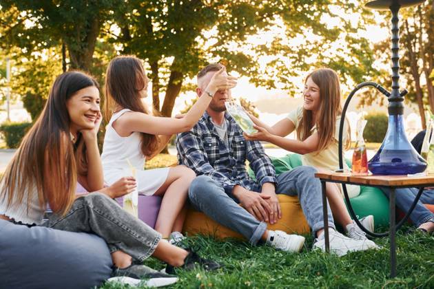 Drinking game. Group of young people have a party in the park at summer daytime., model released, , 51356710.jpg, group, people, hookah, smoking, culture, party, drink, cocktails, sitting, relaxing, resting, alcohol, beverage, armchair, bags, fun, together, outdoors, outside, summer, park, green, grass, caucasian, white, european, ethnicity, casual, clothes, wear, joy, cheerful, wellness, wellbeing, nice, positive, emotions, friends, weekend, leisure, free, time, sunlight, sunshine, beautiful, conversation, talking, communicating, socializing, young RECORD DATE NOT STATED