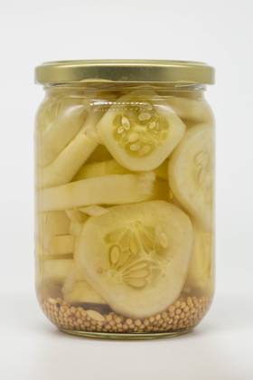 A glass jar filled with sliced pickled cucumbers immersed in vinegar, showcasing mustard seeds at the bottom. Perfect for illustrating food preservation or homemade pickling. Model Released LauraZamora_ID26925_776983_017 Copyright: xLauraxZamorax RECORD DATE NOT STATED
