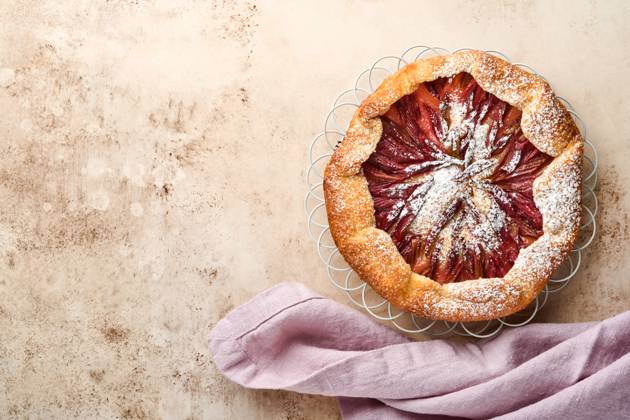Hausgemachte Rhabarber Galette mit Stern-Muster auf alten Beton Tisch Hintergrund gemacht. Prozess des Backens. Offener Kuchen. Weihnachts- und Neujahrsbackwaren. Draufsicht auf selbstgemachte Kuchenkruste auf dem Tisch. Homemade rhubarb galette made with star pattern on old concrete table background. Process of baking. Open pie. Christmas and New Years baked goods. Top view of homemade pie crust on the table. (License=RF) Copyright: xZoonar.com KatsiarynaxHuravax 23348081