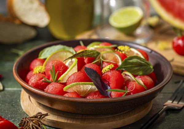 Pikanter Salat aus frischen Wassermelonenkugeln mit Basilikum, Limette, Rosmarin und Fenchel, mit Olivenöl beträufelt, auf dunkelgrüner Tischfläche mit Sonnenlicht Spicy salad of fresh watermelon balls with basil, lime, rosemary and fennel, topping with olive oil on dark green table surface with sunny light Copyright: imageBROKER VictoriaxKondysenko ibxiqx13228618.jpg