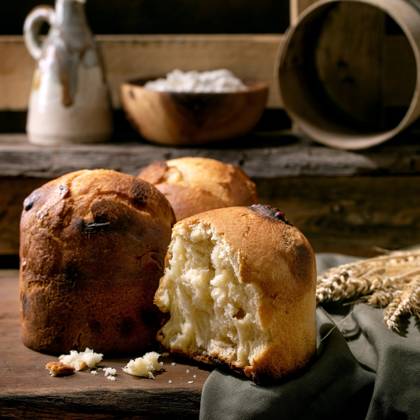Hausgemachtes traditionelles italienisches Brioche-Weizenbrot ganz und halb Homemade traditional italian brioche wheat bread with cheese inside, whole and half. Standing on wooden table in rustic kitchen with kitchen utensil at background. (License=RF) Copyright: xZoonar.com NATASHAxBREENx 23428894