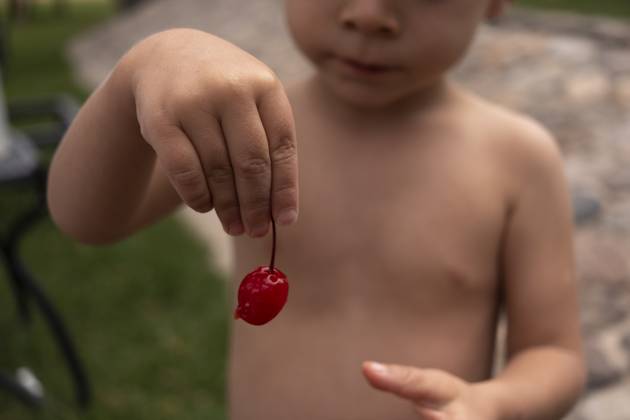 IMAGO Creative, Jahreszeit Sommer, Kirschen Child Holding a Maraschino Cherry San Miguel de Allende, Guanajuato, Mexico R_WDJM250522-1736478-01 ,model released, Symbolfoto