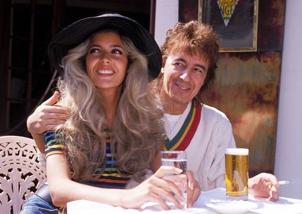 RECORD DATE NOT STATED BILL WYMAN ( THE ROLLING STONES ) & MANDY SMITH Ref: 026 eighties fashion, cricket jumper, sweater, hat, smiling, smoking, cigarette London Great Britain Copyright: x PhilxLoftus CapitalxPicturesx