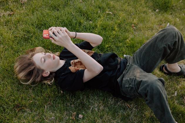 IMAGO Creative, Jahreszeit Sommer, Sommerferien Teenager boy lying on grass using smartphone outdoors Boise, Idaho, United States CR_PHZD250609A-1747604-01 ,model released, Symbolfoto