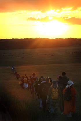 June 21, 2025, Salisbury, England, UK: Visitors walk towards the sun as it rises during the ceremony at Stonehenge. On the longest day of the year thousands of revellers gather at Stonehenge in Wiltshire, to celebrate the Summer Solstice. Neo Druids, Pagans and non-believers congregate around the 5000-year-old stone circle to celebrate the sunrise. The sun rises in perfect alignment with the Heel Stone and Altar Stone proving that ancients in the construction of the stones understood the solar calendar. Salisbury UK - ZUMAmp3_ 20250621_zip_mp3_011 Copyright: xMartinxPopex