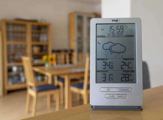 Summer heat, digital thermometer in an attic apartment, city center, outside temperature in the afternoon over 34°C, in the apartment 31°C, apartment without air conditioning, heats up very much, health risk, symbolic image climate change, summer heat apartment
