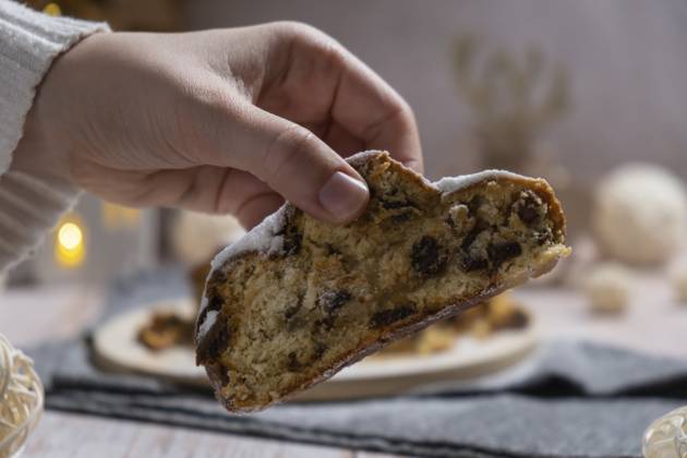 Weibliche Hand, die ein Stück von hausgemachten Weihnachten traditionellen Kuchen Kuchen mit Marzipan Nüsse und getrocknete Früchte Gebäck Dessert Stollen. Winterferien Saison Atmosphäre. Leckere leckere Zusammensetzung nach Hause Tisch Einstellung Textfreiraum Female hand taking slice of Homemade Christmas traditional cake pie with marzipan nuts and dried fruits pastry dessert stollen. Winter holidays season atmosphere. Delicious tasty composition home table setting Copy space Copyright: imageBROKER AnastasiiaxYanishevs ibxiqx14048650.jpg