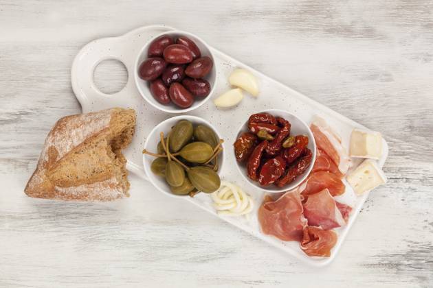 IMAGO Creative, Food, Tapas Tapas von oben. Getrocknete Tomaten, Kapern, Oliven, Käse und Prosciutto Schinken. Italienisches Vorspeisen Konzept Tapas from above. Dry tomatoes, capers, olives, cheese and prosciutto ham. Italian appetizer concept Copyright: imageBROKER Eskymaks ibxiqx13960291.jpg