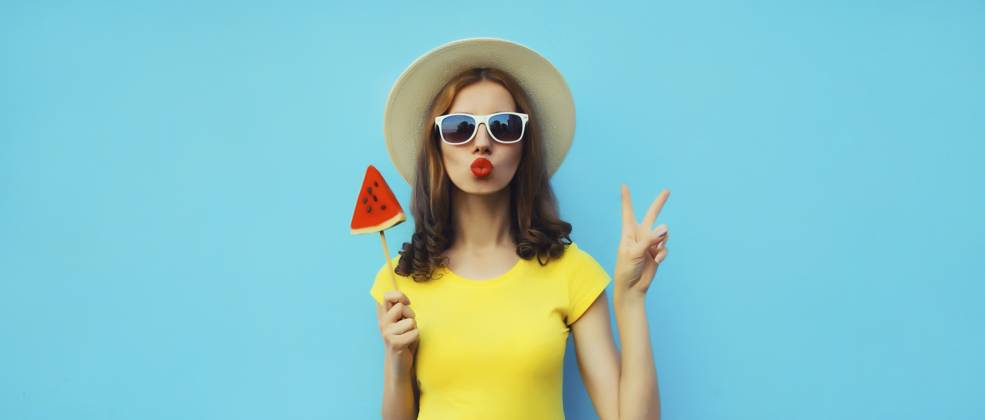 Sommer Porträt der stilvollen jungen Frau mit süßen saftigen Lutscher oder Eis geformt Scheibe Wassermelone trägt Strohhut auf blauen Studio Hintergrund Summer portrait of stylish young woman with sweet juicy lollipop or ice cream shaped slice of watermelon wearing straw hat on blue studio background Copyright: imageBROKER VeronikaxKorneva ibxiqx14269591.jpg ,model released, Symbolfoto ,property released