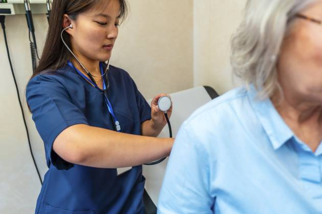 Ärztin mit Stethoskop bei der Untersuchung der Lunge eines älteren Patienten während einer medizinischen Untersuchung im Krankenhauszimmer Female doctor using stethoscope examining lungs of senior patient during medical checkup in hospital room Copyright: imageBROKER UnaixHuizi ibxuhu13938492.jpg ,model released, Symbolfoto ,property released