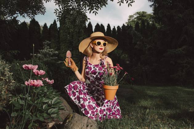 Stylish woman in retro dress gardening with flowers in spring garden model released, Symbolfoto, VSNF03487