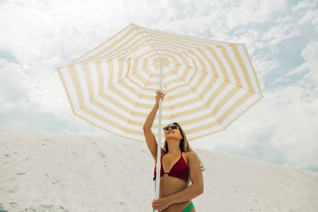 Creative Highlight Symbolbilder Woman in bikini with sunglasses holding umbrella at sandy summer beach model released, Symbolfoto, VSNF03669