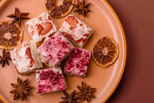 Nougat oder weißes Karamell mit Haselnüssen und Erdbeerstücken. Weißer Nougat Nougat oder weißes Karamell mit Haselnüssen und Erdbeerstücken. Weißer Nougat (License=RF) Copyright: xZoonar.com TetianaxChernykovax 23798392
