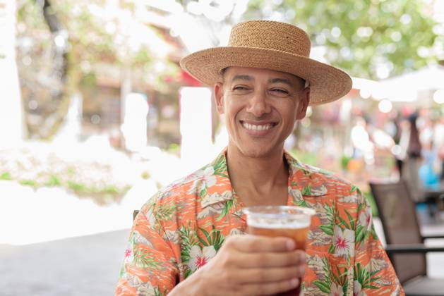 IMAGO Creative, Food, Trend, Iced Coffee Hispanischer Mann mit Eiskaffee in einem Straßencafé, der einen Panamahut und ein kurzärmeliges Hemd trägt A Hispanic male tourist enjoying an iced coffee while sitting at an outdoor cafe on a sunny day, wearing a Panama hat and short sleeve shirt. Casual summer beverage scene. (License=RF) ,model released, Symbolfoto Copyright: xZoonar.com TonixRantalax 23869773 ,model released, Symbolfoto ,property released