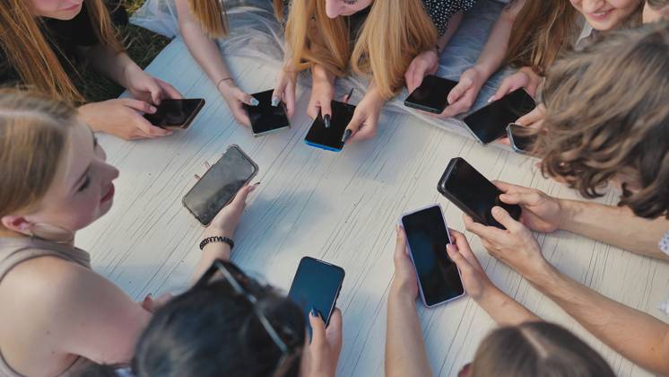 Group of teenagers lying on grass using smartphones together around white table. Group of teenagers lying on grass using smartphones together around white table, model released, , 63354076.jpg RECORD DATE NOT STATED