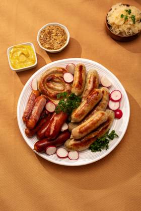 Traditional German sausage platter with sauerkraut Top view of a traditional German platter featuring assorted grilled sausages including Bratwurst and Frankfurters, served with tangy sauerkraut and mustard on an autumn table. Model Released MariaShchipakina_ID30874_1046500_008 Copyright: xMariaxShchipakinax RECORD DATE NOT STATED