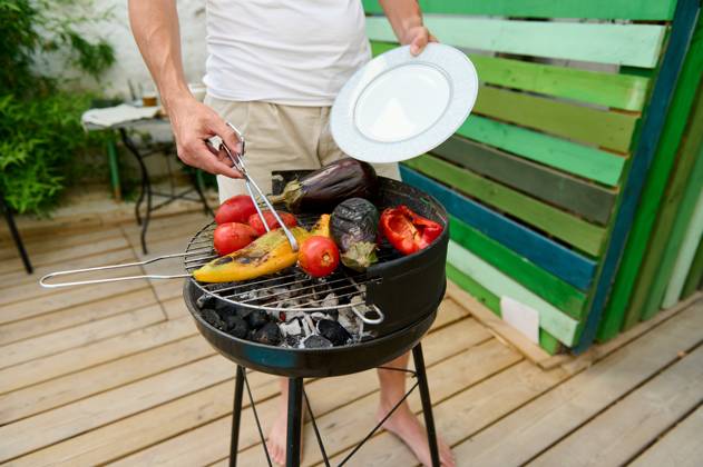 Man grilling vegetables on a backyard BBQ grill, preparing a healthy and delicious outdoor meal A man grilling assorted vegetables, including tomatoes, eggplant, and bell peppers, on a backyard BBQ. The scene captures a healthy and delicious outdoor meal preparation., model released, , property released, , 61018526.jpg RECORD DATE NOT STATED