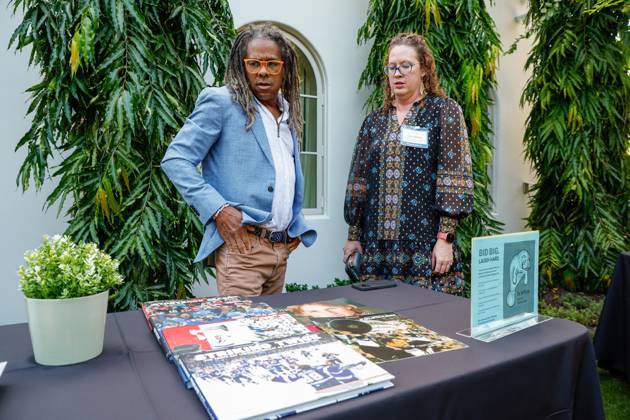 October 23, 2025, St. Petersburg, Florida, USA: Tampa Bay Times photojournalist Dirk Shadd and Traci Johnson, managing editor for sports, production and visuals, look over a table they just set up with books and magazines during the annual Cocktails and News fundraiser event on Thursday, Oct. 23, 2025, in St. Petersburg. St. Petersburg USA - ZUMAs70_ 20251023_zan_s70_056 Copyright: xJeffereexWoox