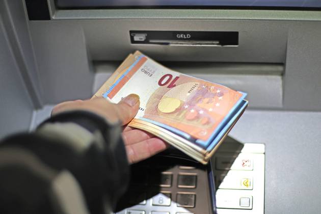 Cash supply from an ATM A person withdraws cash from an ATM