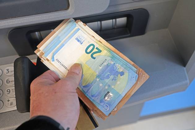 Cash supply from an ATM A person withdraws a large amount of cash from an ATM