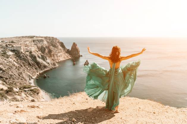 Woman green dress sea. Female dancer posing on a rocky outcrop high above the sea. Girl on the nature on blue sky background. Fashion photo. Woman green dress sea. Female dancer posing on a rocky outcrop high above the sea. Girl on the nature on blue sky background. Fashion photo, model released, , 61782316.jpg RECORD DATE NOT STATED