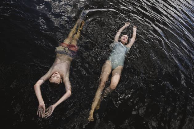 Teens floating and smiling in summer lake wearing swimsuits model released, Symbolfoto, EYAF03632