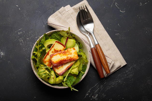 Halloumi Avocado Salat Schüssel gesund vegetarische Ernährung Ernährung von oben gesehen Fried halloumi cheese and sliced avocado salad with mixed green leaves, healthy and gourmet vegetarian meal, black background (License=RF) Copyright: xZoonar.com OlenaxYeromenkox 24282854