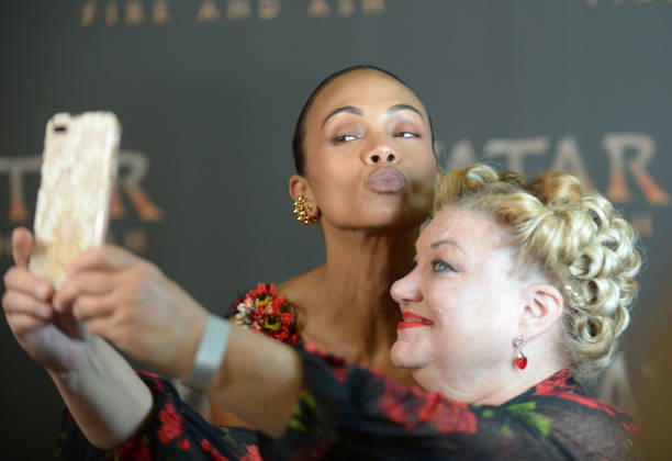 MIAMI, FLORIDA - DECEMBER 12: Zoe Saldana take a selfie with member of the press during the Miami Special Screening of Avatar: Fire and Ash at AMC Sunset Place 24 in Miami, Florida on December 12, 2025. Copyright: xmpi10 MediaPunchx