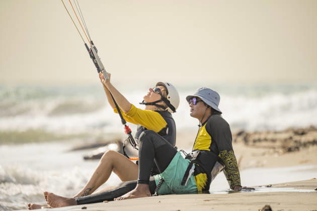 MR_ID31343_22933_DarioImitola.jpg, MR_ID31343_22932_SoniaFenoglio.jpg Student and instructor sit on the sandy shore of Salinas del Rey, Atlantico, Colombia, during a kitesurf lesson. The instructor guides the student as they prepare to catch the waves. Model Released VictorCuenca_ID31343_1065775_004 Copyright: xVictorxCuencax
