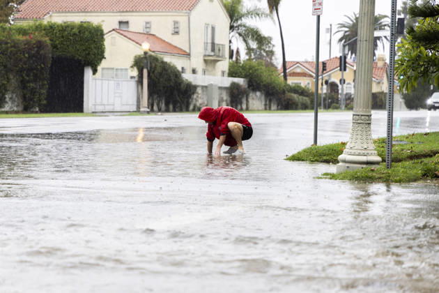 December 24, 2025, Los Angeles, California, USA: A man cleans out debris from a storm drain in the East Hollywood area of Los Angeles while threats of flooding and travel delays persist through Christmas. A powerful atmospheric river brings steady rain that officials warn could trigger flooding, mudslides, and debris flows. Los Angeles USA - ZUMAh182 20251224_znp_h182_001 Copyright: xMatthewxHoenx