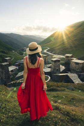 Reisende, hübsche Frau im roten Maxisommerkleid, genießt den Wellness Lifestyle bei Sonnenuntergang in den Bergen in Ushguli, Georgia, mit malerischer Tallandschaft Traveler pretty woman in red maxi sundress enjoying mountain sunset wellness lifestyle in Ushguli Georgia with scenic valley landscape Copyright: imageBROKER EvaldasxMikoliunas ibxemi15189298.jpg ,model released, Symbolfoto ,property released
