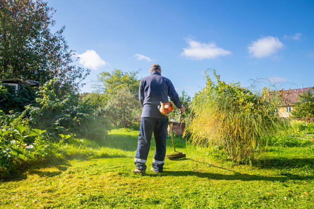 Senior man uses grass trimmer to cut overgrown lawn in his backyard Chelyabinsk, Chelyabinsk Oblast, Russia CR_STCJ260106-1921656-01 ,model released, Symbolfoto