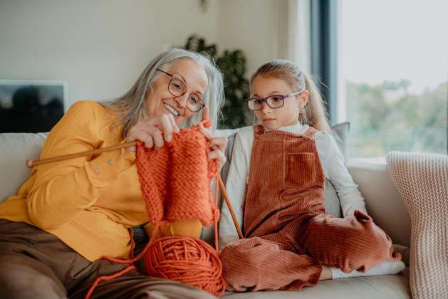 Grandmother teaching young girl how to knit, spending weekend with her. Grandmother teaching young granddaughter how to knit, spending weekend with her. model released