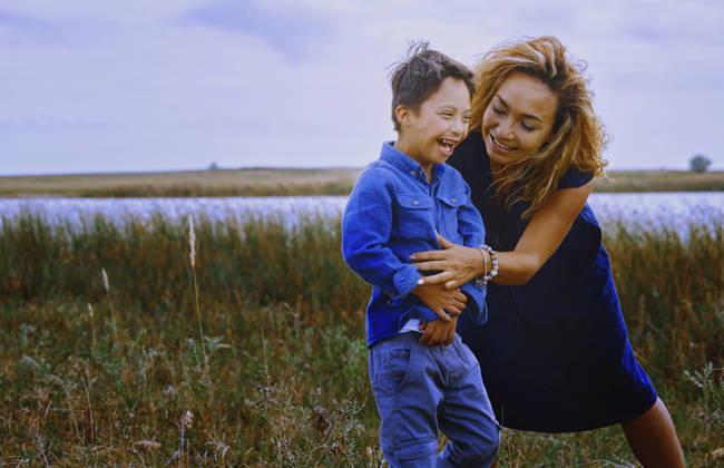 Mother and boy with Down syndrome laughing together outdoors in nature model released, Symbolfoto, AZF01100