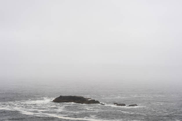 Coastal landscape with small rock in the fog on Chiloe Chile, Patagonia gray sea with low waves dark rocks small island in the haze Chiloe, 15 12 2025 Chiloe Chile Copyright: xHaukexPfluegerx