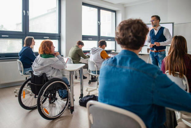 Inclusive classroom scene with student using wheelchair. Inclusive classroom scene with student using wheelchair.Accessible school environment. model released