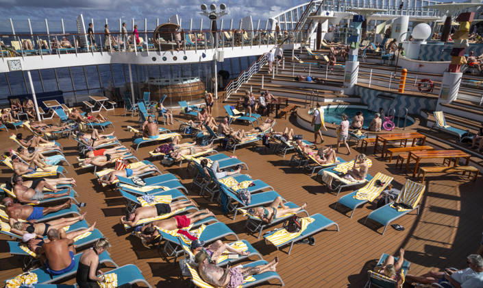 Relaxing on deck on the high seas Passengers on an AIDAblu cruise ship enjoy the voyage through the Caribbean St John s Antigua and Barbuda on the sun deck