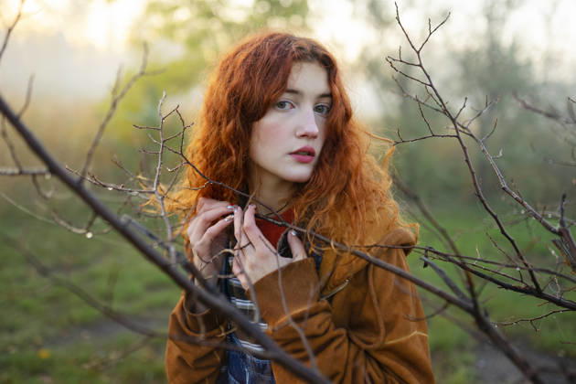 Red-haired woman in orange hoodie and denim overall in foggy forest model released, Symbolfoto, VCF01242