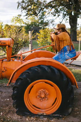 Black woman on orange tractor in cowboy hat and jacket Gurnee, Illinois, United States CR_WVNP260219-1960149-01 ,model released, Symbolfoto