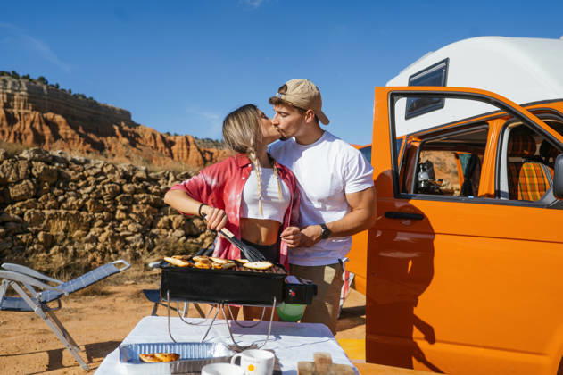 Couple enjoying a romantic cookout in Red Canyon Spain A couple shares a loving moment while cooking outdoors with a scenic view of Red Canyon, Spain in the background. An expression of love and adventure in a picturesque setting. Model Released JoseLuisCarrascosa_ID32450_1105872_185 Copyright: xJosexLuisxCarrascosax