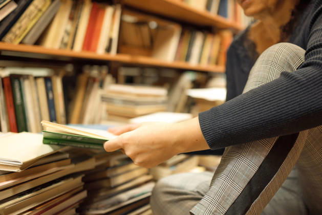 Eine ältere Frau legt alte Bücher in der Bibliothek aus. Sie sitzt auf dem Boden, umgeben von Bücherregalen. An elderly woman lays out old books in the library. She is sitting on the floor surrounded by shelves of books, concentrating on her task. (License=RF) ,model released, Symbolfoto Copyright: xZoonar.com AKIFYEVAxSVETLANAAx 24740744 ,model released, Symbolfoto ,property released