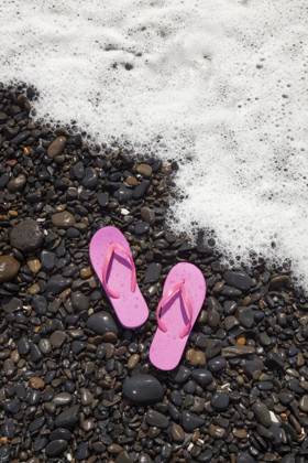 A pair of pink flip flops rest on wet rocks as a foamy ocean wave approaches the shore in Florence, Oregon. Footwear,United States,A pair of pink flip flops rest on wet rocks as a foamy ocean wave approaches the shore in Florence, Oregon.  A pair of pink flip flops rest on wet rocks as a foamy ocean wave approaches the shore in Florence, Oregon.