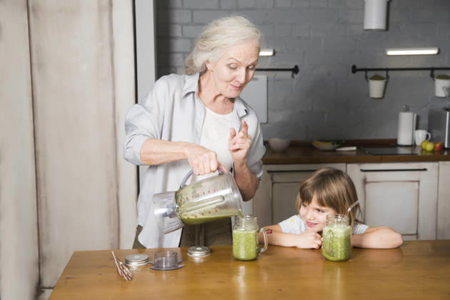 Gesunde Ernährung in der Familie, Vegetarismus. Lebensstil im Alter. Großmutter und Enkelin trinken Smoothie aus Grünzeug und Superfoods in der Küche zu Hause. Healthy nutrition in the family, vegetarianism. Senior lifestyle. grandmother and granddaughter drink smoothie from greenery and superfoods in the kitchen at home (License=RF) ,model released, Symbolfoto Copyright: xZoonar.com UliaxZotaninax 24740110 ,model released, Symbolfoto ,property released
